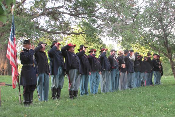 The crews of Company M's guns  present arms during the National Anthem at the Sunday evening Compton Heights band concert at Francis Park in St. Louis, MO.