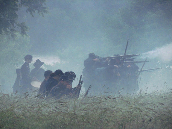 The Saturday rain held the powder smoke close to the ground, partially obscuring the action.  Union infantry advances on the rebel works during the Saturday battle at the 2014 event at Pittsfield, I..  