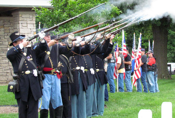 The honor guard fires the third volley of a21 gun salute with Patriot Guard in the background at the ceremony on June 14, 2014, at Jefferson Barracks National Cemetery in south St. Louis County, MO.