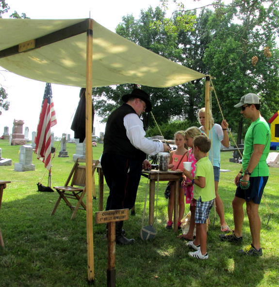 Steve Allen discusses the canister round display at the St. Francis of Assisi church picnic at Luebbering, MO, July 26, 2015.